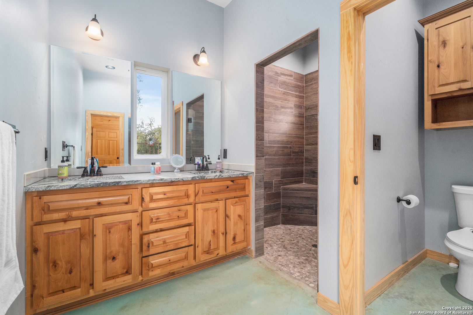 1110 Grandview Circle Bandera, TX 78003 - Photo 22 of 45 a bathroom with a granite countertop sink a toilet a mirror and shower