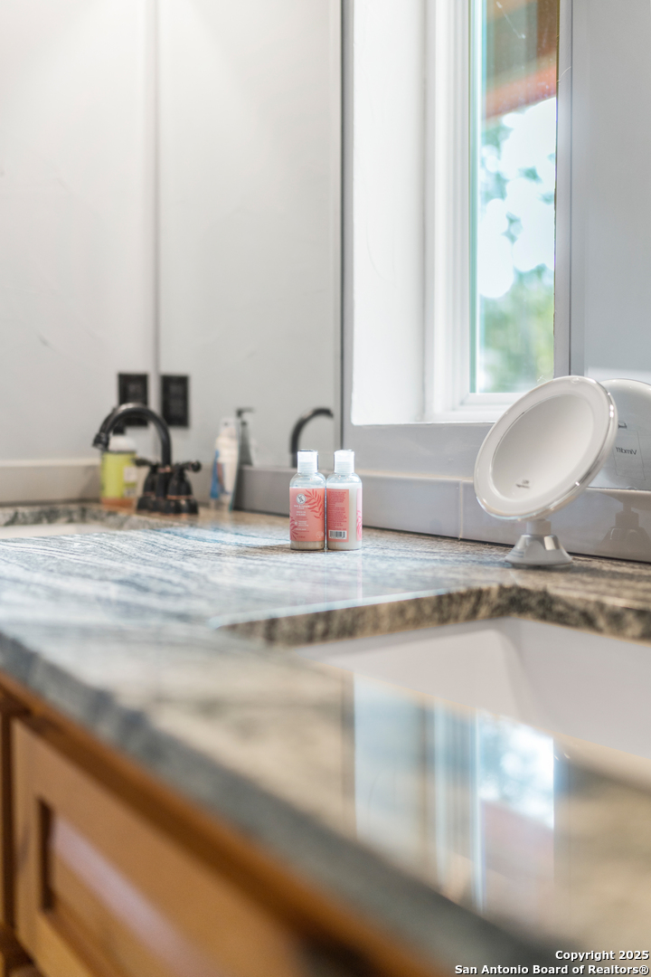 1110 Grandview Circle Bandera, TX 78003 - Photo 38 of 45 a bathroom with a granite countertop sink and a mirror
