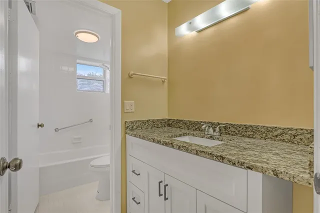 a bathroom with a granite countertop sink and a mirror