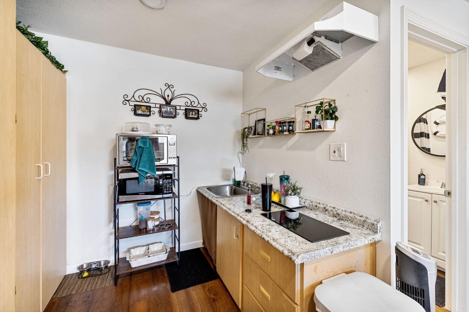1345 Peach Avenue Clovis, CA 93612 - Photo 23 of 27 a kitchen with a stove a refrigerator and a wooden floor