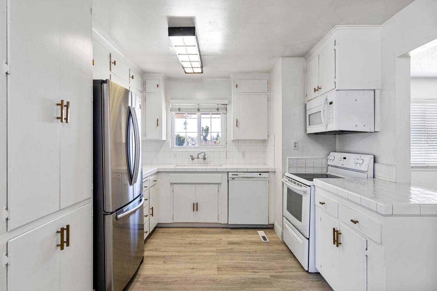 1345 Peach Avenue Clovis, CA 93612 - Photo 10 of 27 a kitchen with white cabinets sink and refrigerator