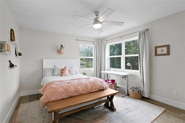 a living room with a flat screen tv and a ceiling fan