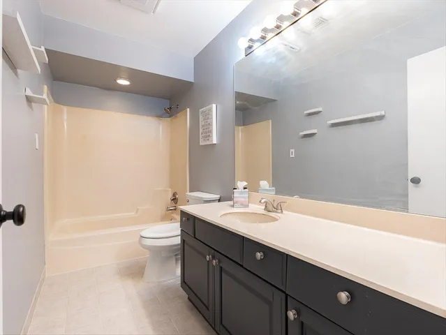 a bathroom with a double vanity sink toilet mirror and bathtub