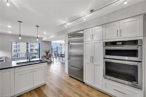 a kitchen with kitchen island white cabinets stainless steel appliances and wooden floor