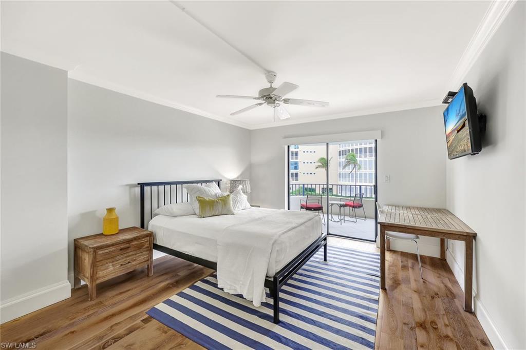4451 Gulf Shore Boulevard North, Unit 506 Naples, FL 34103 - Photo 17 of 32 a bedroom with a bed and wooden floor
