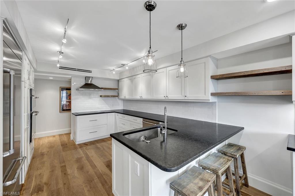 4451 Gulf Shore Boulevard North, Unit 506 Naples, FL 34103 - Photo 5 of 32 a kitchen with stainless steel appliances granite countertop a sink a counter space and cabinets