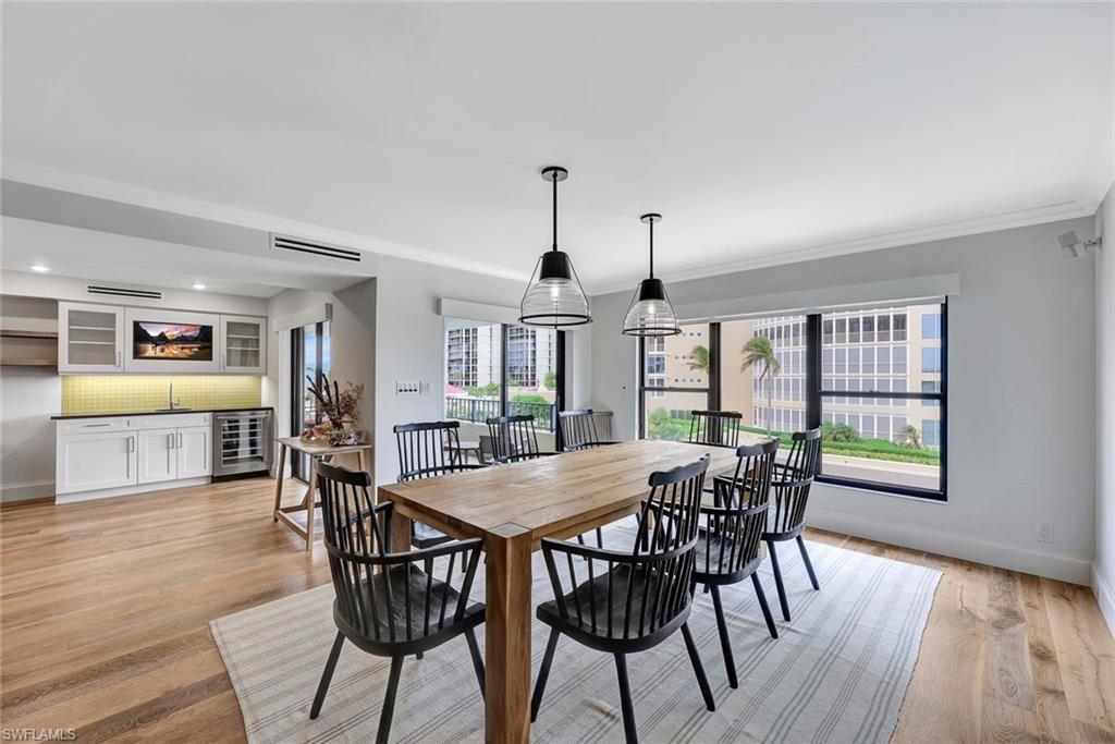 4451 Gulf Shore Boulevard North, Unit 506 Naples, FL 34103 - Photo 6 of 32 a view of a dining room with furniture window and wooden floor