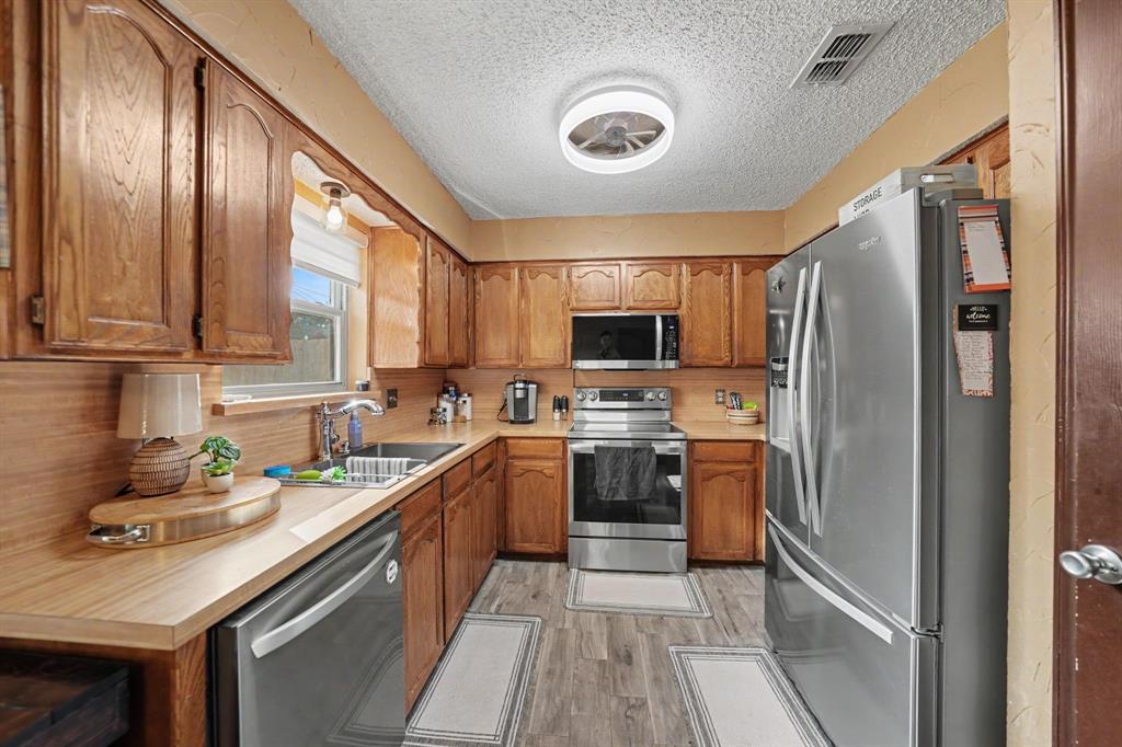 7624 Maple Hill Road Watauga, TX 76148 - Photo 16 of 20 Wood-finish cabinetry paired with light countertops
