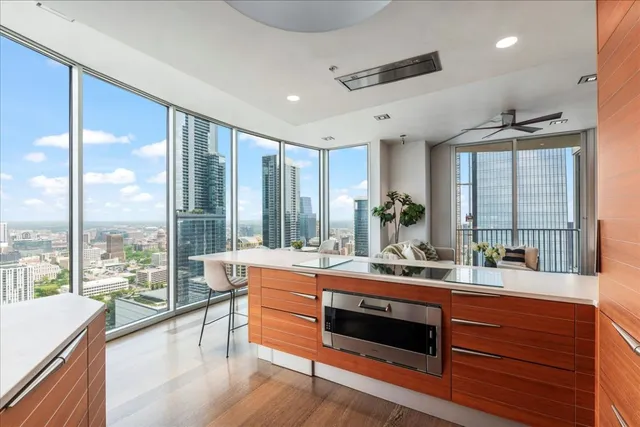 a room with stainless steel appliances kitchen island granite countertop a sink and wooden floor