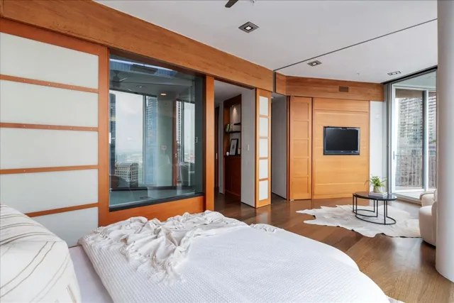 a bedroom with a large bed and large windows