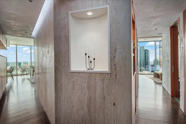 a view of a hallway with wooden floor windows and livingroom with furniture