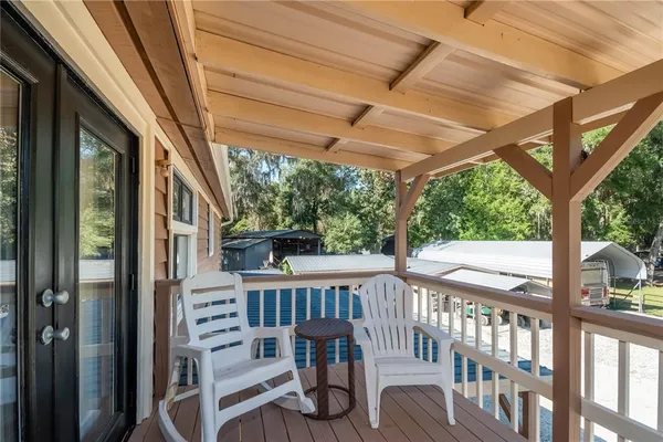 a view of a patio with table and chairs potted plants with wooden floor and fence