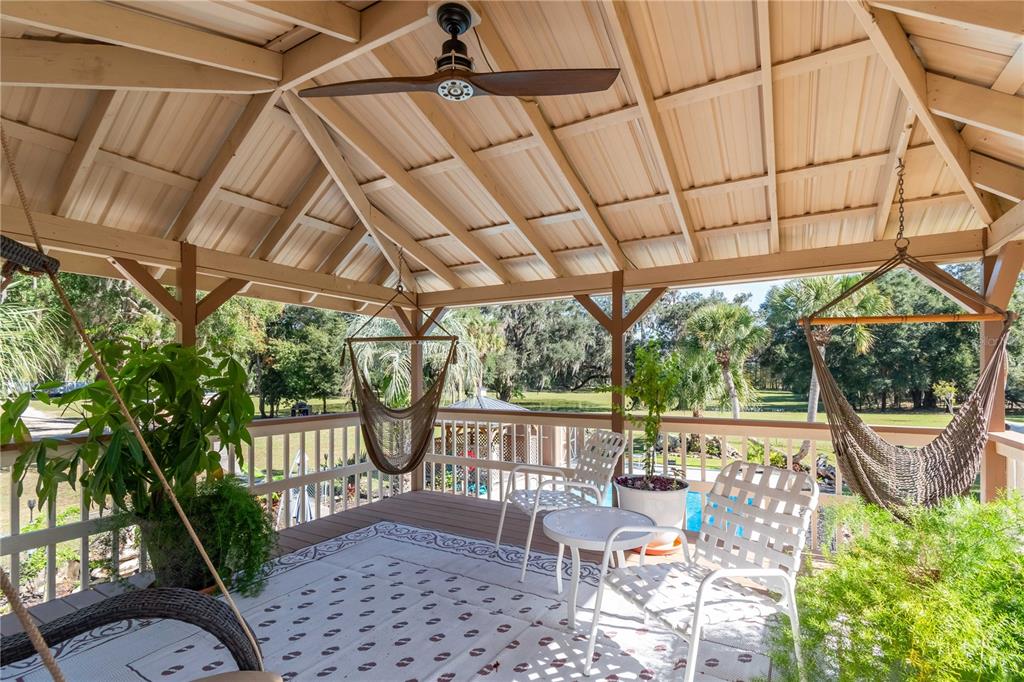 15615 Northeast 21st Avenue Road Citra, FL 32113 - Photo 37 of 98 a view of a patio with table and chairs potted plants with wooden floor and fence