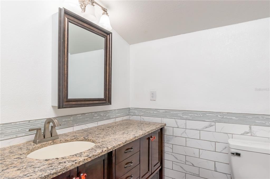 15615 Northeast 21st Avenue Road Citra, FL 32113 - Photo 68 of 98 a bathroom with a granite countertop sink and a mirror