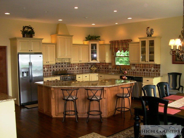 186 Harper Trail Boone, NC 28607 - Photo 4 of 46 a kitchen with stainless steel appliances kitchen island granite countertop a kitchen island and chairs in it