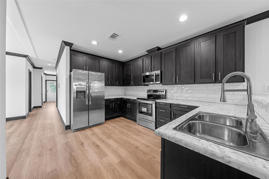 202 6th Street Mount Calm, TX 76673 - Photo 2 of 23 a kitchen with granite countertop a refrigerator sink and cabinets