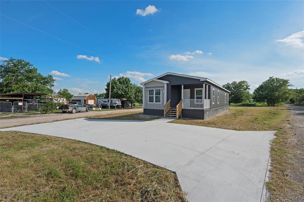 202 6th Street Mount Calm, TX 76673 - Photo 21 of 23 a front view of a house with a garden and yard