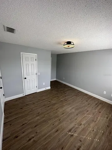 a view of an empty room with wooden floor