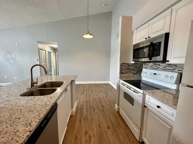 a kitchen with microwave a stove and cabinets