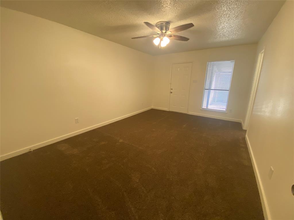 3108 Timber Ridge Point Grapevine, TX 76051 - Photo 13 of 16 an empty room with windows and chandelier fan