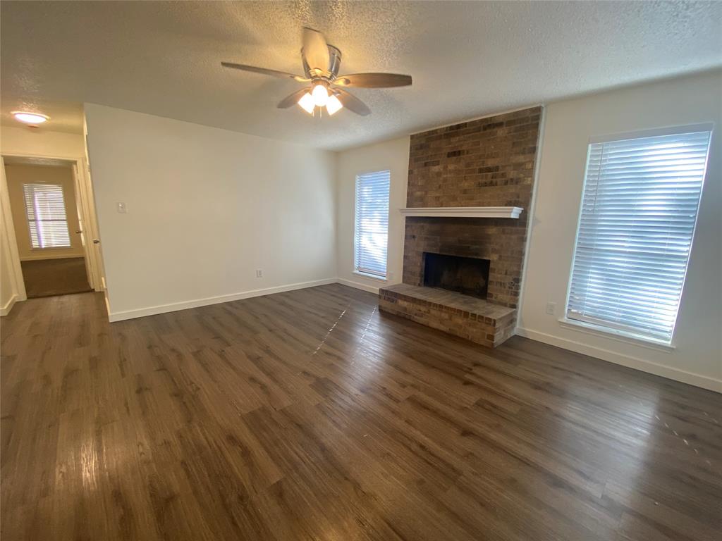 3108 Timber Ridge Point Grapevine, TX 76051 - Photo 3 of 16 an empty room with wooden floor windows and fireplace