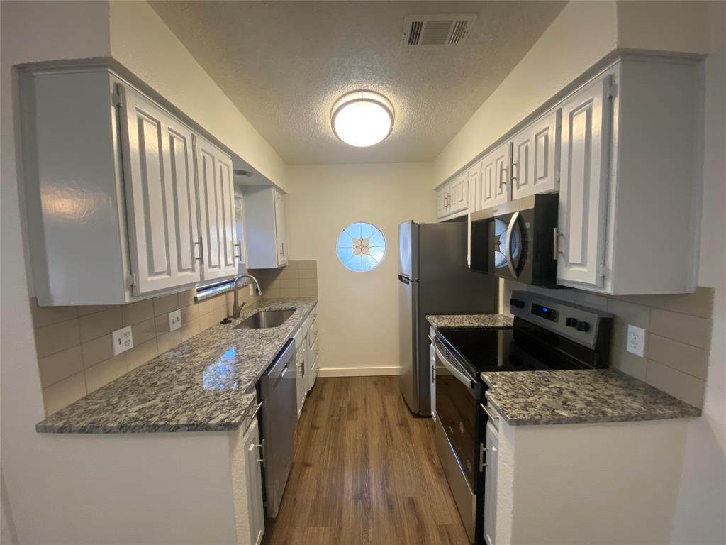 3108 Timber Ridge Point Grapevine, TX 76051 - Photo 5 of 16 a kitchen with granite countertop a sink a counter top space appliances and cabinets