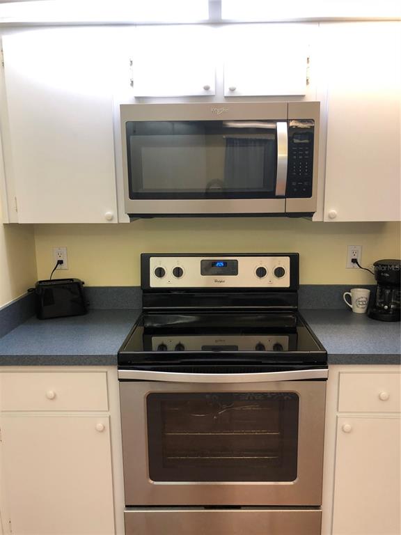 7867 Southwest 115th Loop Ocala, FL 34476 - Photo 14 of 40 a kitchen with microwave stove and cabinets