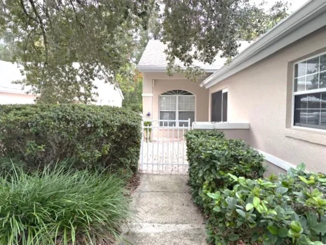 a front view of a house with a yard and potted plants