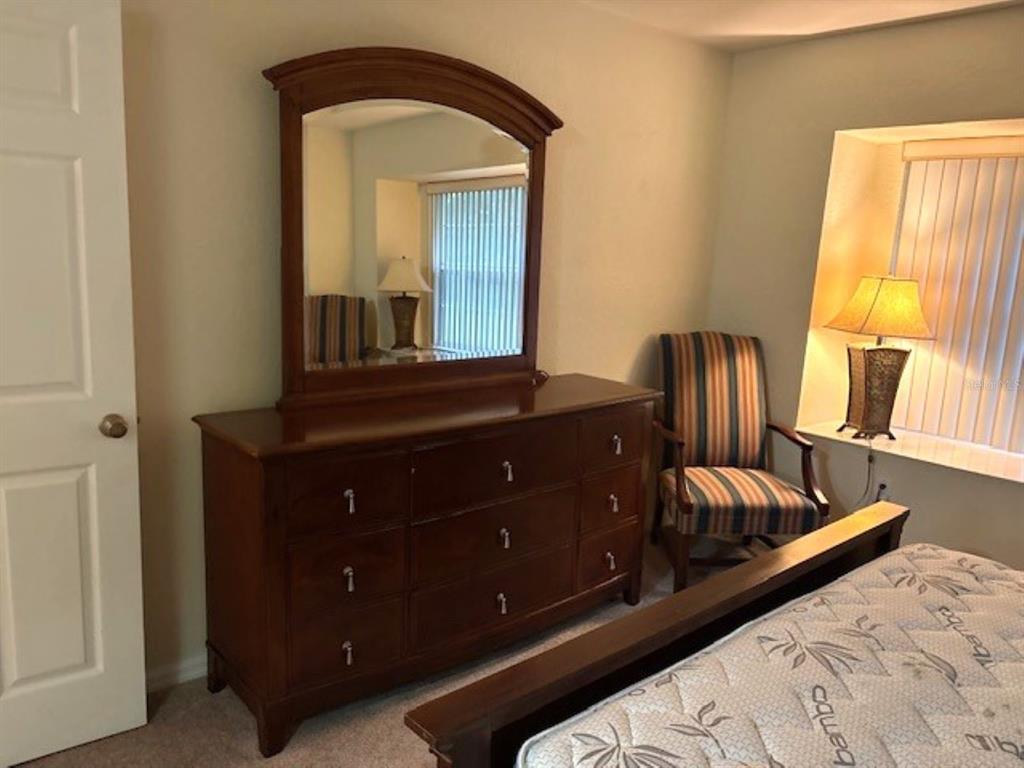 7867 Southwest 115th Loop Ocala, FL 34476 - Photo 30 of 40 a bedroom with a bed and a mirror on dresser