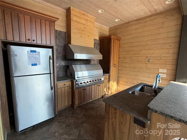 a kitchen with stainless steel appliances granite countertop a refrigerator a sink and a stove