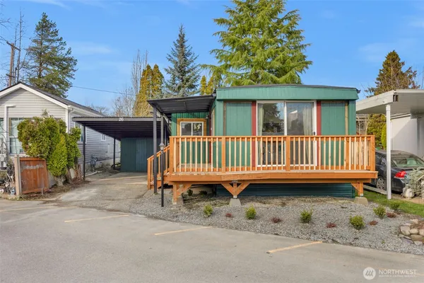 a view of a house with a deck and a yard