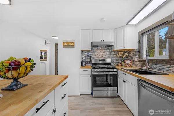 a kitchen with stainless steel appliances granite countertop a sink stove and cabinets