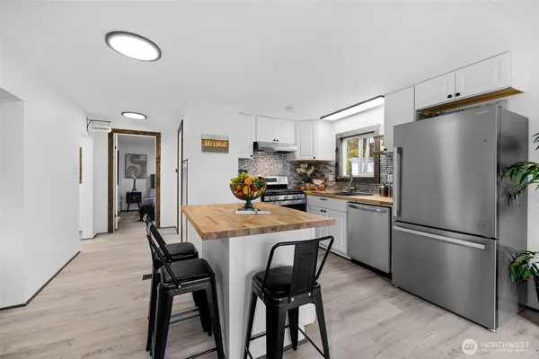 a kitchen with a refrigerator a dining table and chairs