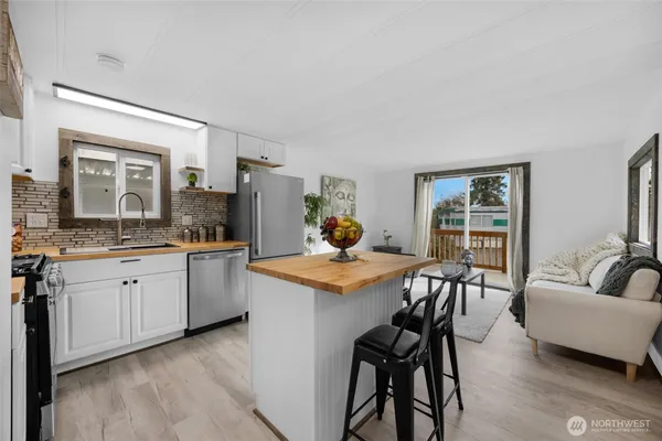 a open kitchen with granite countertop a sink and chairs