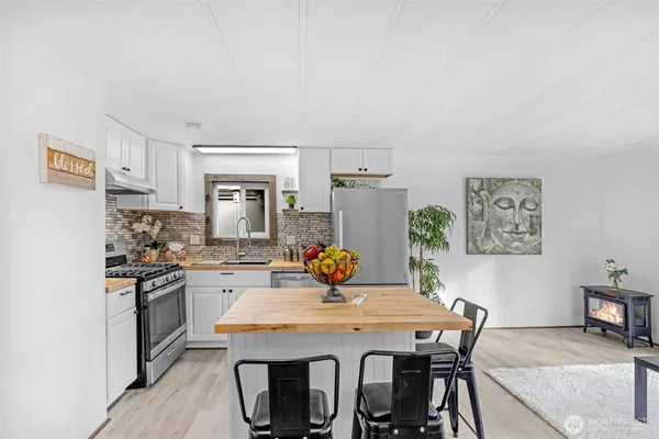 a view of a dining room with furniture a kitchen and chandelier