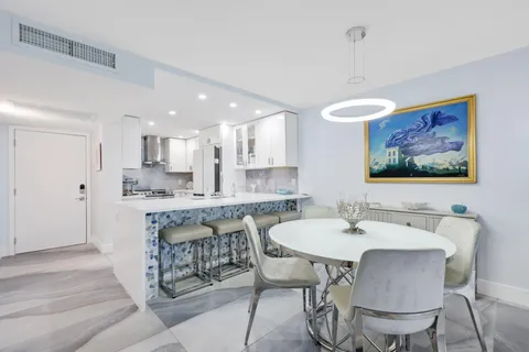 a living room with furniture a large window and a dining table