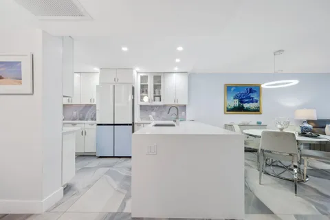 a kitchen with a sink a refrigerator and cabinets