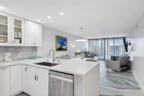 a kitchen with white cabinets appliances and a sink