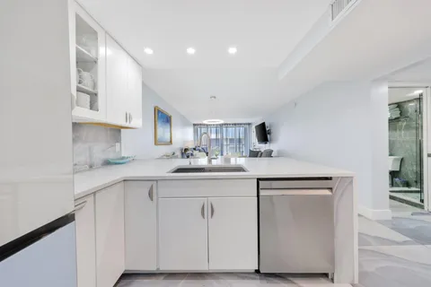 a kitchen with stainless steel appliances granite countertop a table chairs sink and cabinets