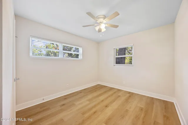 a view of a room with wooden floor and window