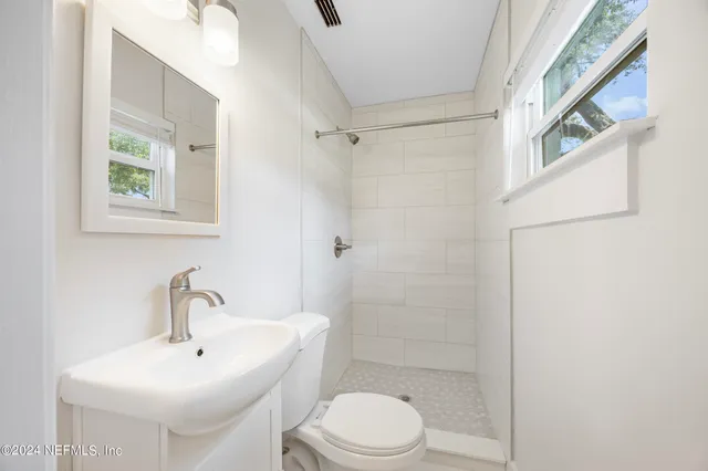 a white toilet sitting next to a bathroom sink