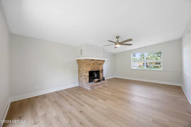 an empty room with windows and fireplace