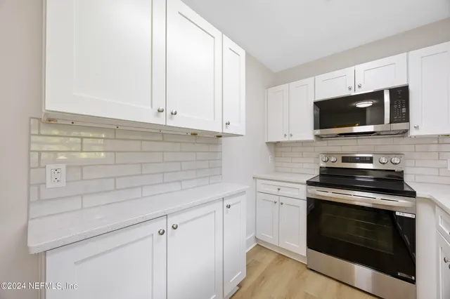 a kitchen with cabinets stainless steel appliances and a sink