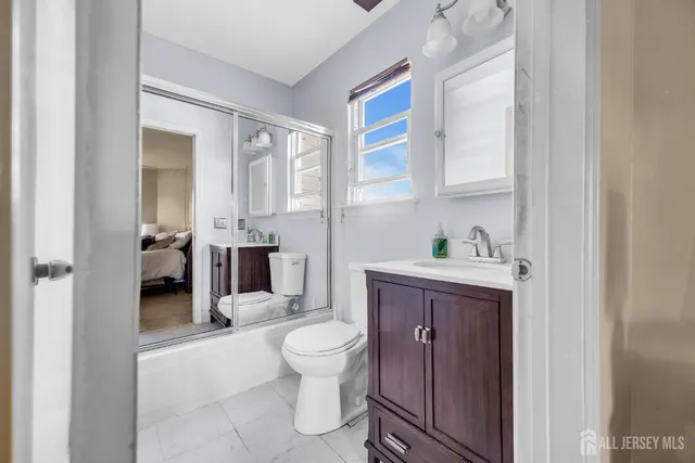 a spacious bathroom with a granite countertop toilet a sink and a mirror