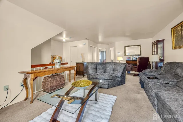 a living room with furniture and a dining table with kitchen view