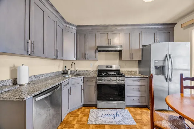 a kitchen with stainless steel appliances granite countertop a stove a refrigerator and a stove