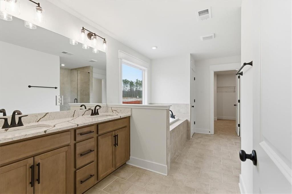 4749 Cooling Water Circle Powder Springs, GA 30127 - Photo 16 of 35 a spacious bathroom with a double vanity sink a mirror and a bathtub