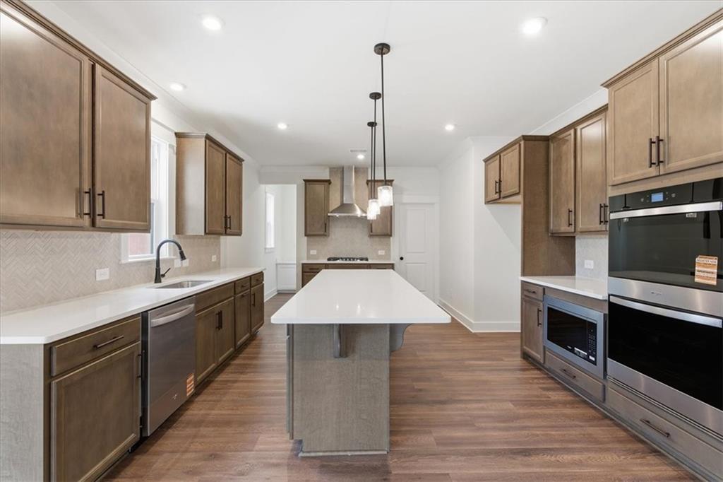 4749 Cooling Water Circle Powder Springs, GA 30127 - Photo 5 of 35 a large kitchen with stainless steel appliances kitchen island granite countertop a stove a sink dishwasher and a refrigerator with wooden floor