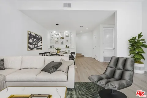 a living room with furniture and a chandelier