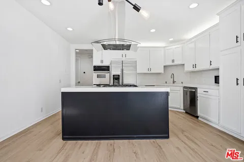 a kitchen with stainless steel appliances granite countertop a stove a sink and a refrigerator